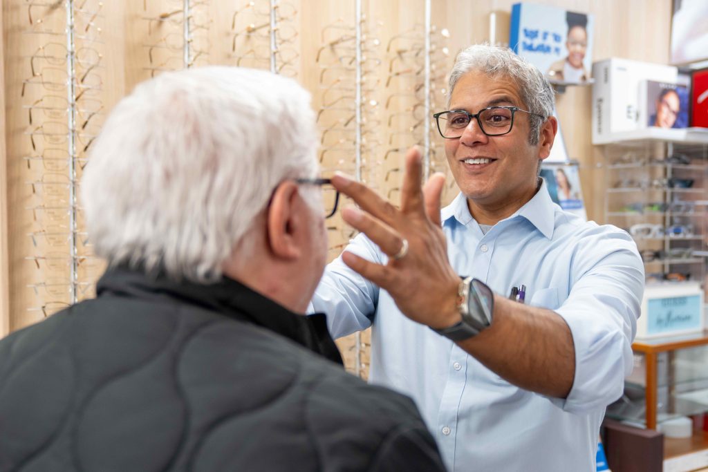 Optician fitting glasses to a customer