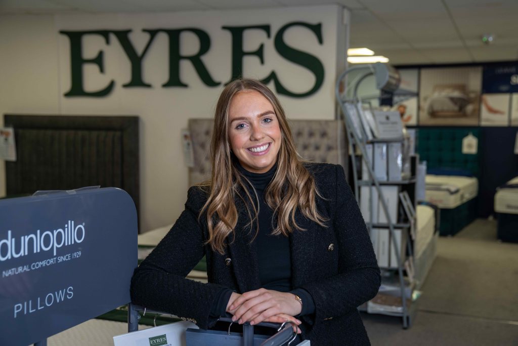 Staff member at Eyres, with furniture in the background