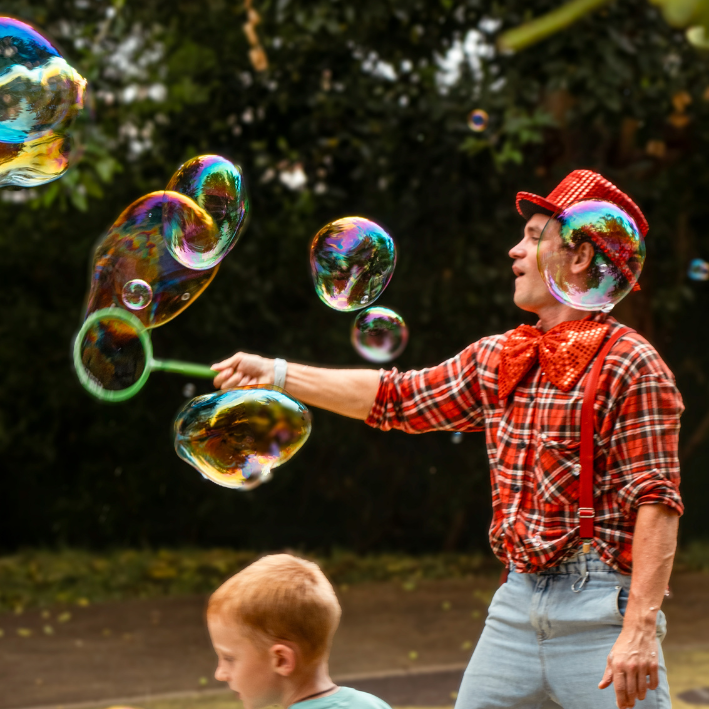 Performer blowing bubbles for a child